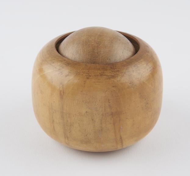 Turned boxwood massage ball in wooden socket, which forms grip