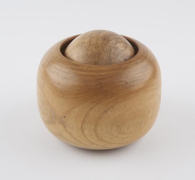 Turned wooden massage ball encased in turned wooden socket