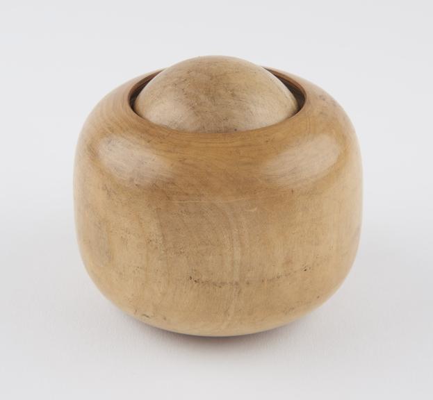 Turned boxwood massage ball in wooden socket, which forms grip