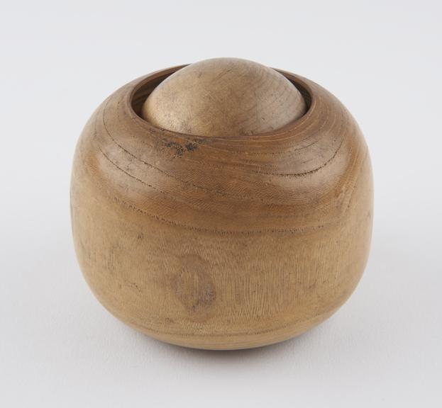 Turned wooden massage ball encased in turned wooden socket