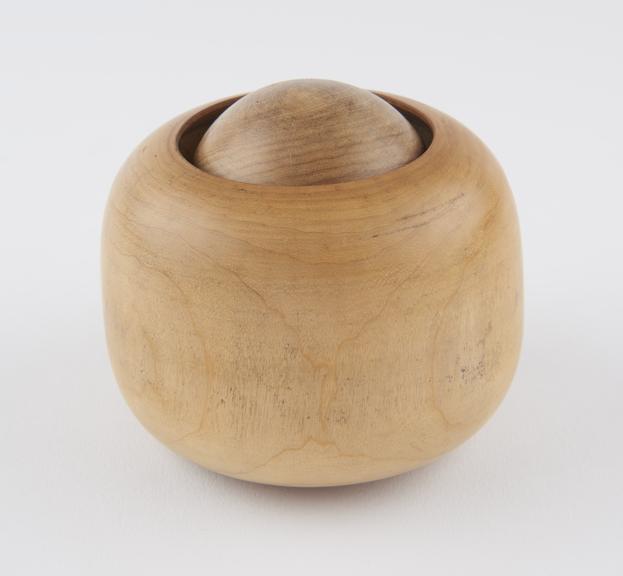 Turned wooden massage ball encased in turned wooden socket