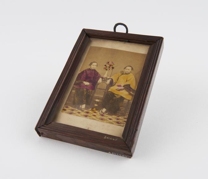 Photograph of two Chinese women, coloured in, in wooden frame