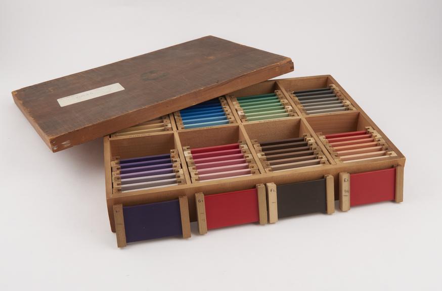 Box of 64 coloured 'slides', no maker marked