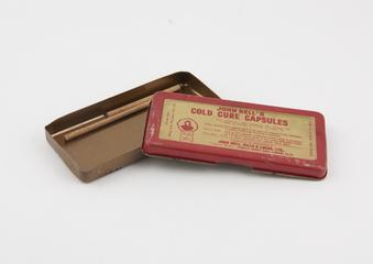 Tin (unrelated) containing two pegs