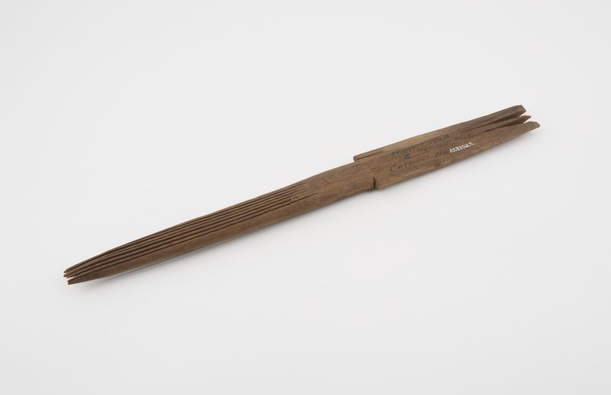 Long double-sided wooden comb, paddle-shaped, made by Toda