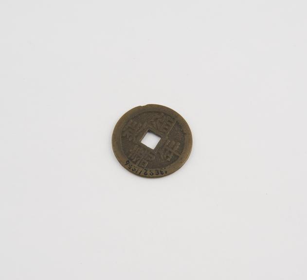 Amuletic brass coin, disc-like with square hole in centre