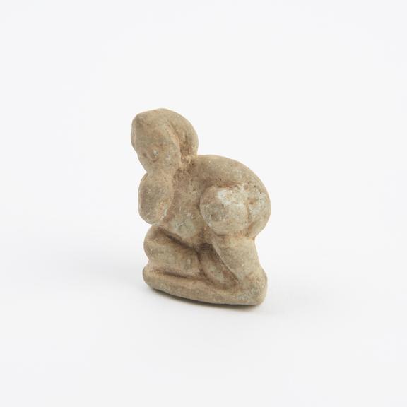 Phallic amulet, figure reclining with finger in mouth