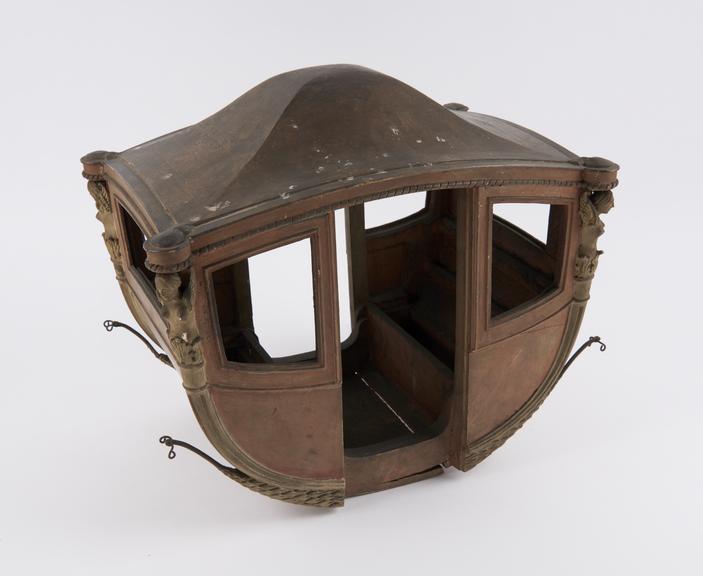 Model of coach body with winged female figure at each corner