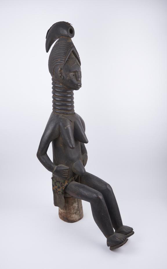 Carved wooden Minserch' figure of female sitting on stool