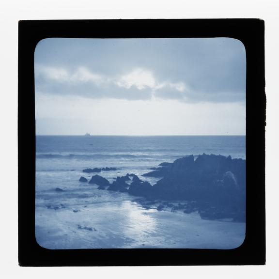 A magic lantern slide showing a seascape with rocks by Birt