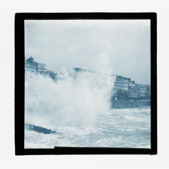 A magic lantern slide of sea waves crashing against the shore