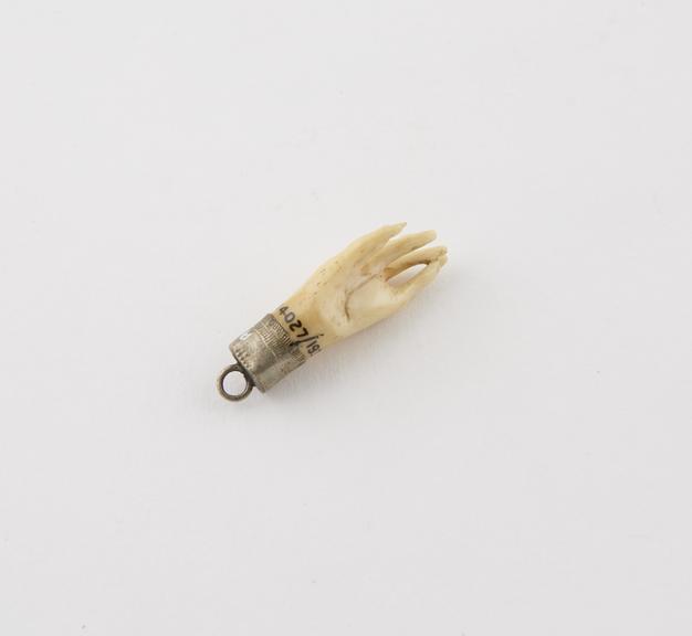 Amulet in form of bone hand in metal mount with suspenision