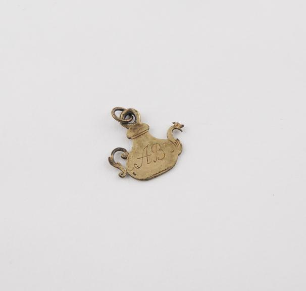 Flat gold plated pendant amulet in form of model teapot