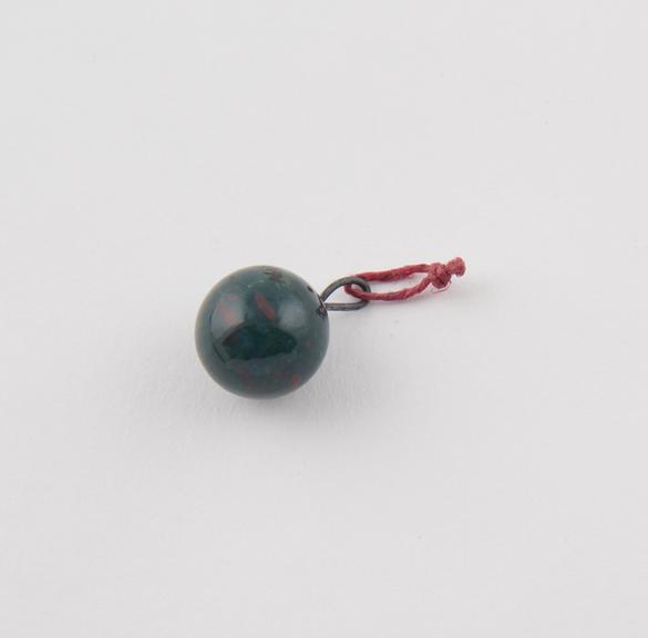 Spherical glass(?) bead  pendant, green, speckled red