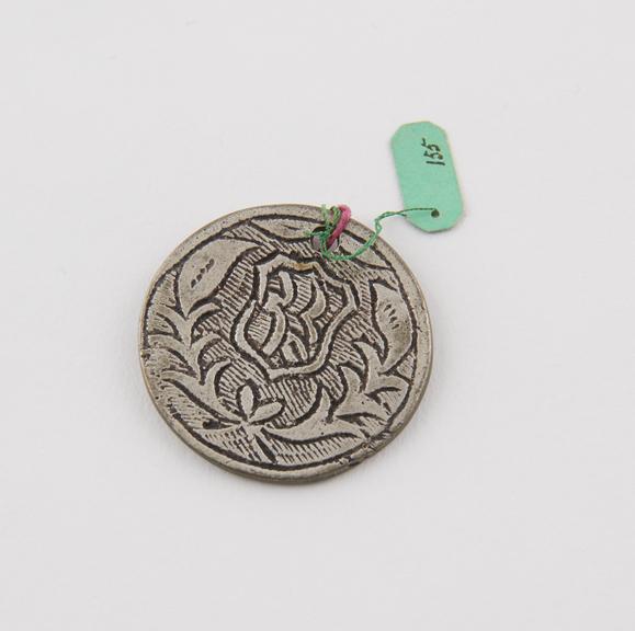 Perforated silver (?) medallion, inscribed with wreath