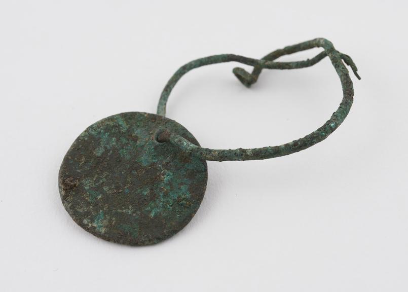 Bronze coin perforated with bronze wire loop, badly corroded