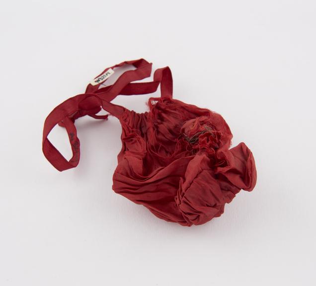 Dried frog in red silk bag, damaged, red ribbon draw cord