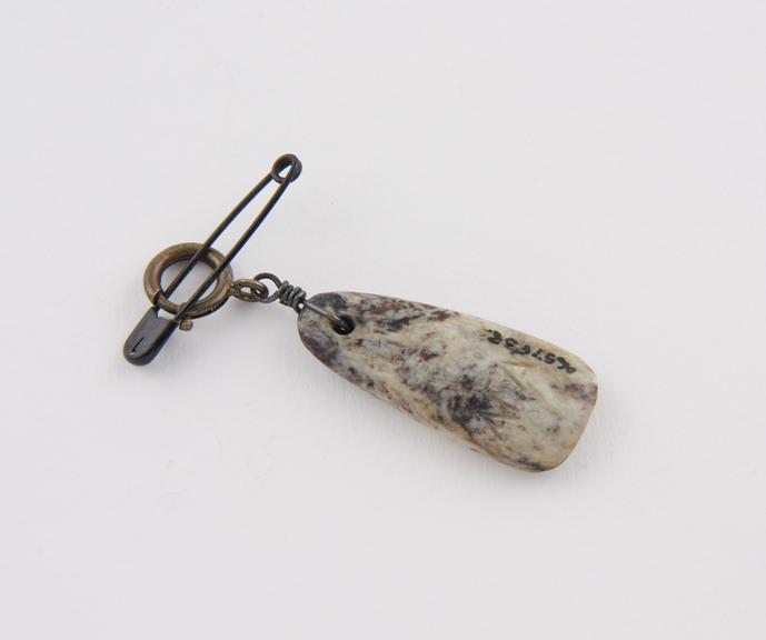 Amuletic pendant of mottled grey stone with brass clasp and