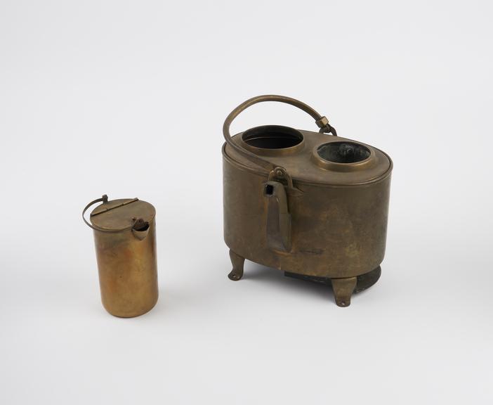 Oval brass wine heater, with spout and bent hinged handle