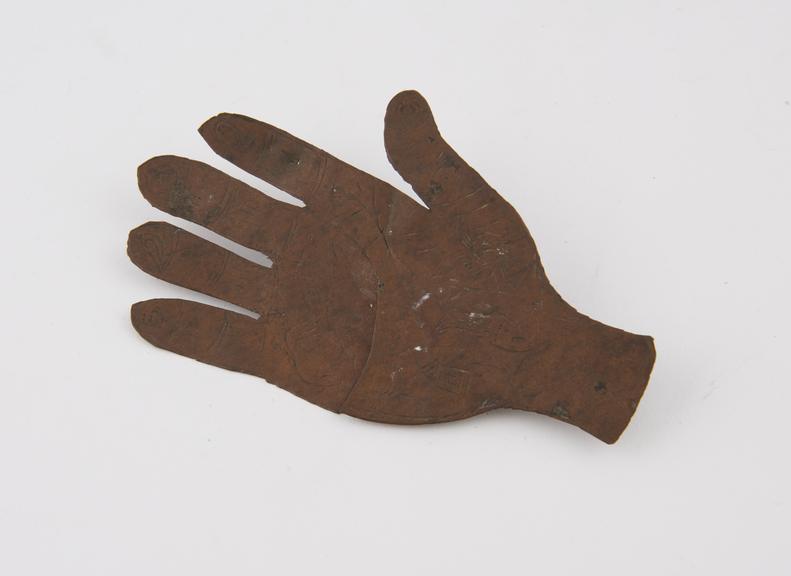 Amulet, flat brass plaque in form of a hand