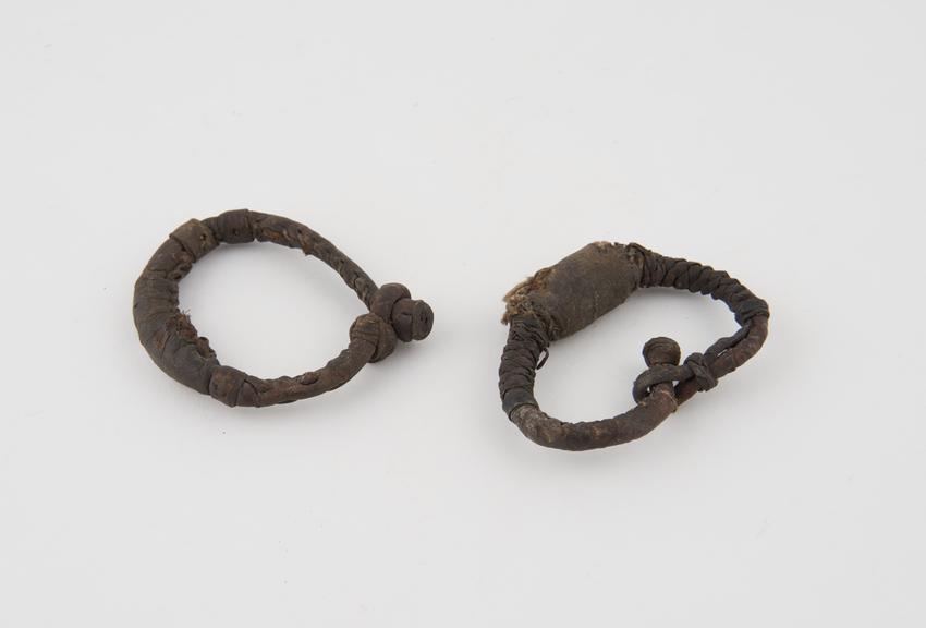 Two leather bracelets containing amulets in bulbous dilations