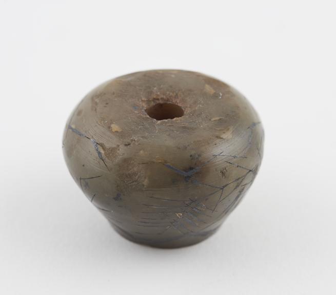 Marble bead(?), inlaid with silver, to prevent miscarriage