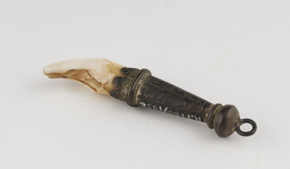 Amulet consisting of curved tooth with silver mount topped with