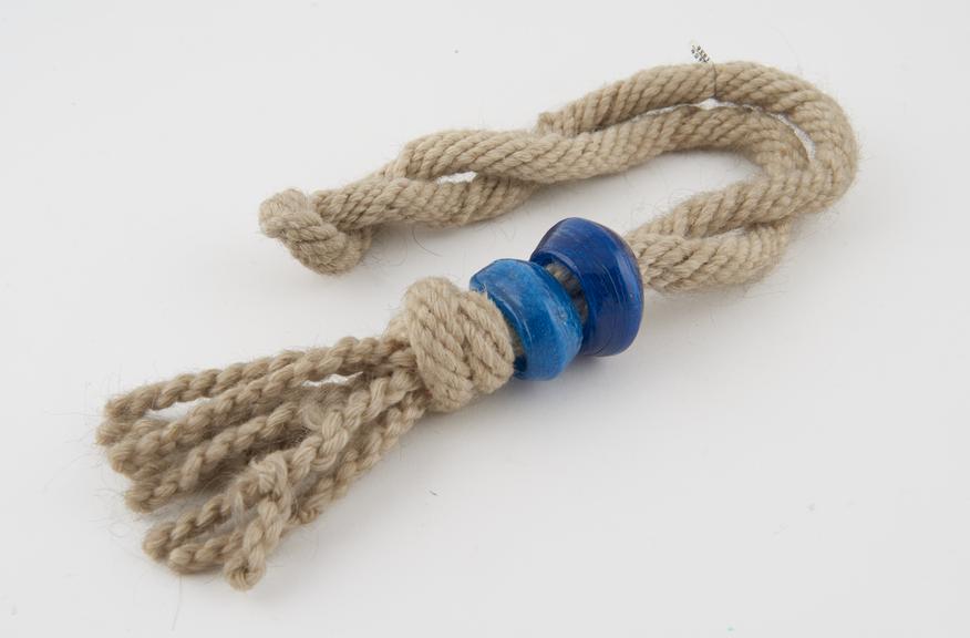 Rope of twisted wool, threaded with two glass beads or rings