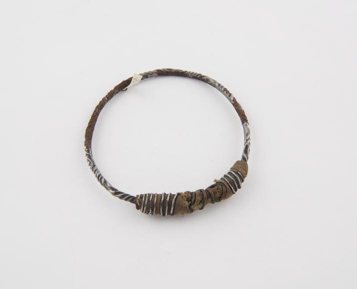 Twisted steel armlet, with piece of cloth bound on with wire