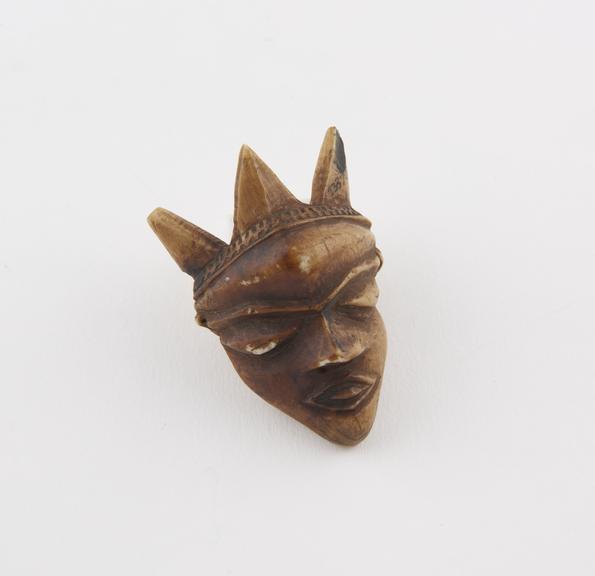 Ivory amulet, in the form of a carved face