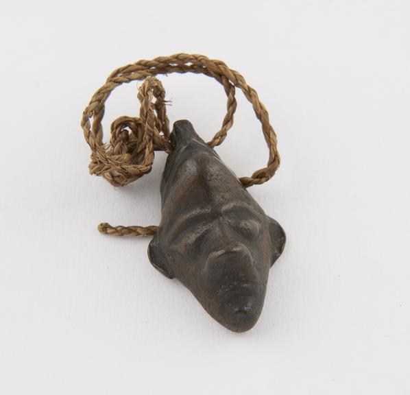 Metal amulet, in the form of a face, by the Bapende tribe, Zaire