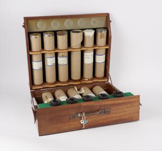 Wooden case containing eleven charts rolled in cardboard tubes and five turrets with airport abbreviations