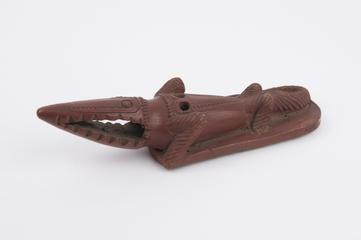Red earthenware skin scraper in form of crocodile toward off evil spirits