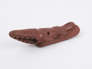 Red earthenware foot-scraper in the form of a crocodile with scraper on base