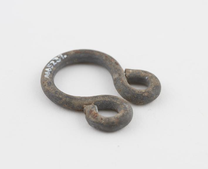 Iron amulet, shaped like a torc with curled ends