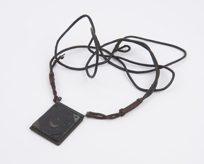 Rectangular wood and copper amulet with decorative metal inlay