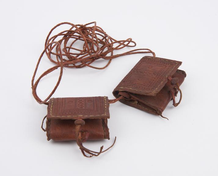 Amulet, pair of leather pouches on thongs