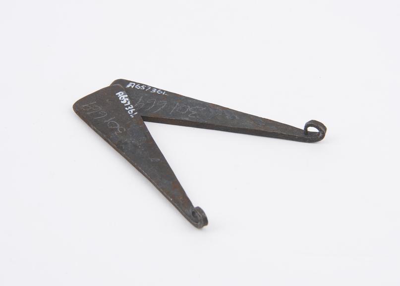 Pair of iron triangular shaped slabs with hooked tips, amulatic