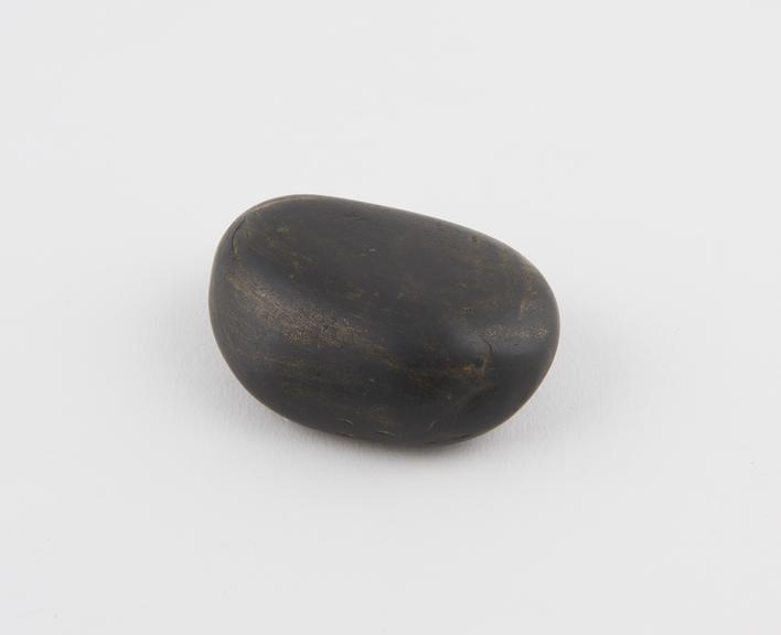 Smooth ovoid black stone with traces of gold paint