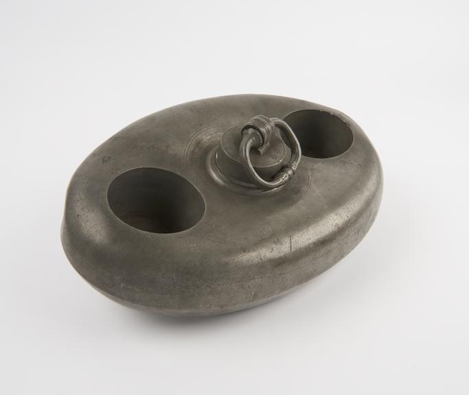 Oval pewter hot water bottle with screw top lid with ring