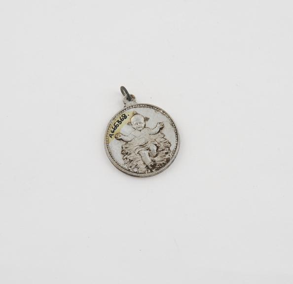 Coin-like amulet with loop and ring for suspension