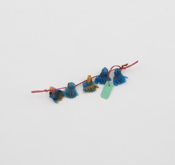 5 moulded blue and yellow glass hands, threaded on string