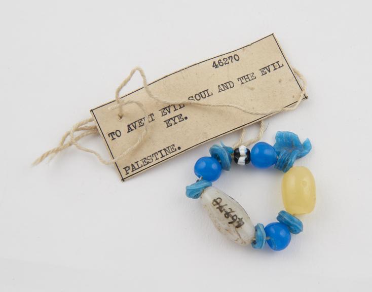 10 coloured glass beads and 1 crudely executed glass hand