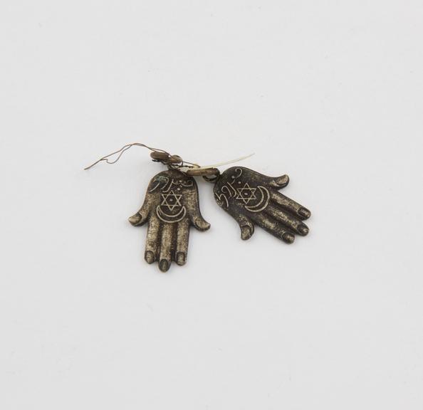 2 amulets in form of moulded hands, flat backed