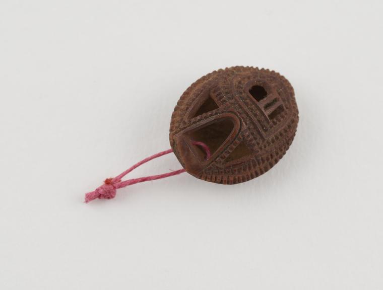 Amuletic pendant consisting of carved apricot stone