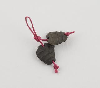 Pair of black metal(?) beads, amuletic, heart-shap