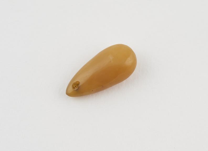 Pendant, drop shaped, yellow opaque amber bead