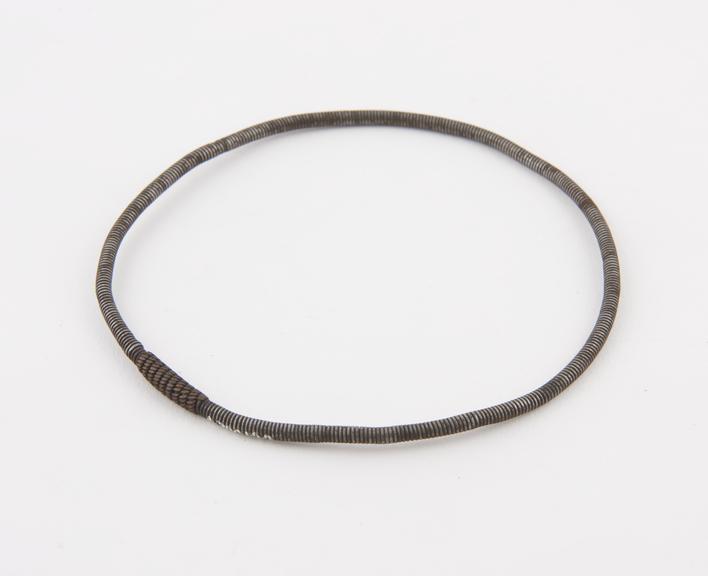 Armlet of tightly twisted steel wire, bound with copper wire