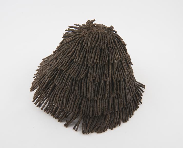 Wig-like cap of fringed and plaited string