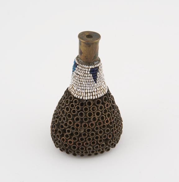 Small cone shaped headdress made from cartridge case worn by